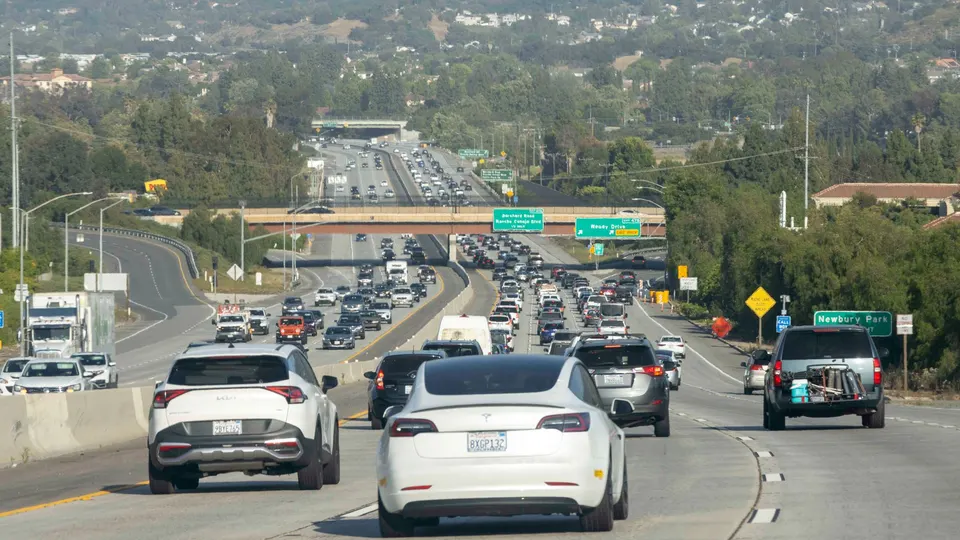 Heavy traffic on a California freeway with hills in the background