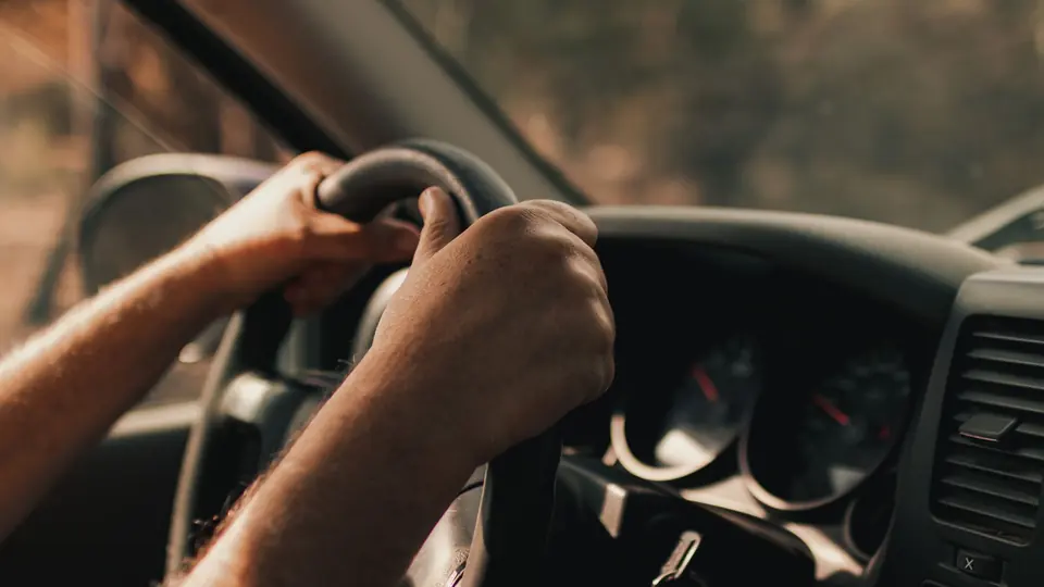 A driver's hands on a steering wheel